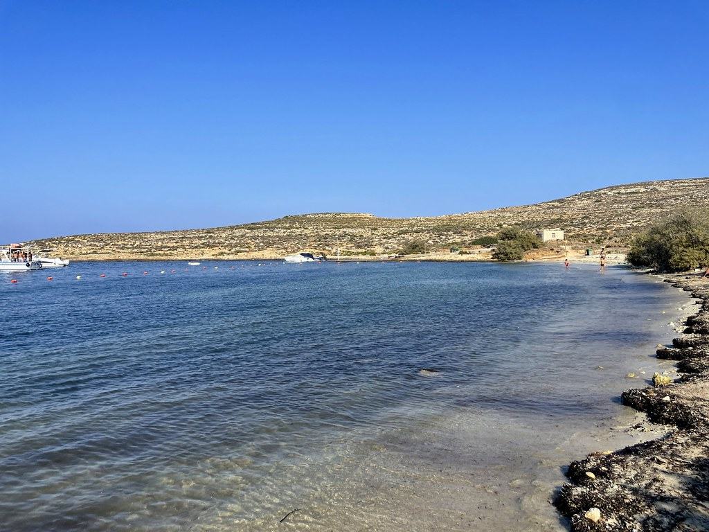 The sandy shallows of Santa Marija Bay on Comino's north coast, with the low headland behind